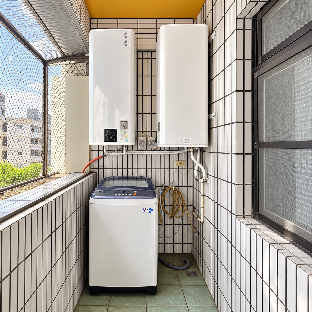 兩台白色方形電熱水器壁掛於磁磚陽台，洗衣機設於下方，左側可見陽台欄杆。